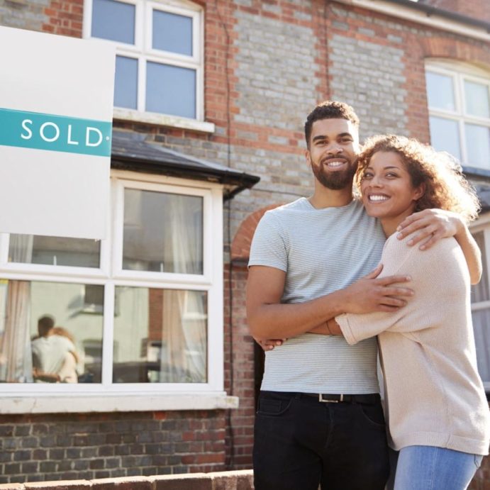 Portrait Of Excited Young Couple Standing Outside New Home Together Portrait Of Excited Young Couple Standing Outside New Home Together