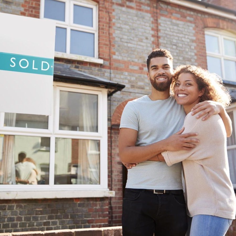 Portrait Of Excited Young Couple Standing Outside New Home Together Portrait Of Excited Young Couple Standing Outside New Home Together